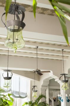 the ceiling fan is hanging from the ceiling in the room with plants and other decorations