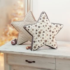 two decorative stars sitting on top of a table