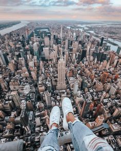 a person standing on top of a tall building in the middle of a large city