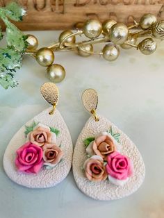 two pairs of earrings with flowers on them