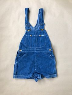 Unworn, originating from the archive of a jeans shop that closed down late last century.  Unworn vintage Lee Cut Off Shorts with tag still attached.  100% cotton, sized W28, made in USA. Pockets in the front and back and two bib pockets.  Waist from top of waistband: 71cm / 28" For information about our full terms & conditions please review our Shop Policies. Retro Denim Blue Overalls With Pockets, Retro Medium Wash Cotton Overalls, Vintage Denim Blue Overalls With Pockets, Retro Dark Wash Shortalls With Pockets, Vintage High Rise Bottoms With Pockets, Vintage Blue Cotton Overalls, Vintage Blue Shortalls, Vintage Cotton Bottoms In Medium Wash, Vintage Medium Wash Cotton Bottoms