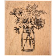 a wooden stamp with flowers in a mason jar