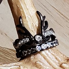 two black and white rings sitting on top of a piece of wood with diamonds in the middle