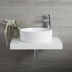 a white bowl sink sitting on top of a counter next to a faucet