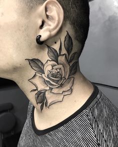 a man with a black and white rose tattoo on his neck, behind the ear