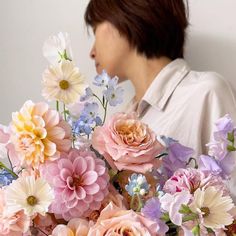 a woman holding a bouquet of flowers in front of her face