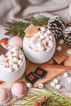 two bowls filled with marshmallows sitting on top of a wooden cutting board