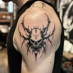 a man with a tattoo on his shoulder has a skull and antelope head