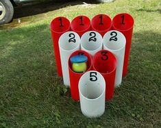 a set of cups with numbers on them sitting in the grass next to a car