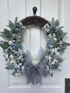 a wreath with white flowers and blue leaves