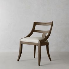 a wooden chair with white upholstered seat and backrest, against a gray wall