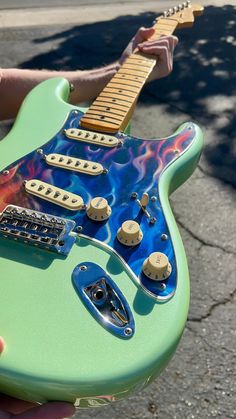 a person holding an electric guitar on the street