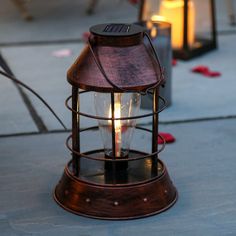 an old fashioned lantern is lit on the sidewalk