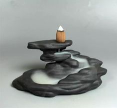 a black and white rock with a small wooden object on it's top in the middle