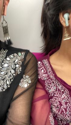 two women sitting next to each other wearing earrings