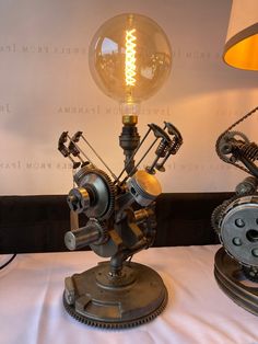 two light bulbs sitting next to each other on top of a white cloth covered table