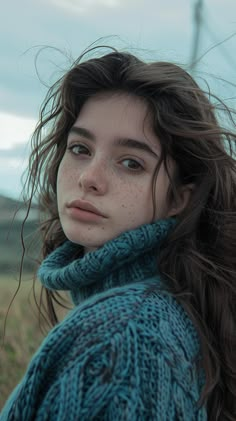 a woman with freckled hair standing in a field