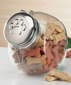 a glass jar filled with dog treats on top of a table