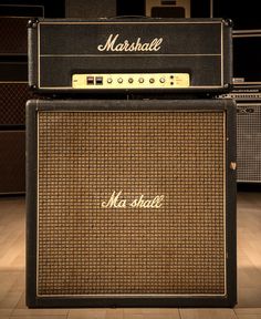 two marshall amps stacked on top of each other in a room with wood flooring