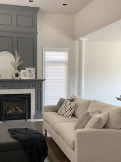 a living room filled with furniture and a fire place next to a mirror on the wall