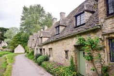 an old stone house with ivy growing on the windows