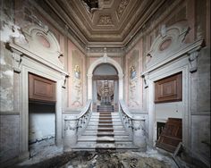 an abandoned building with stairs leading up to the second floor and another set of doors