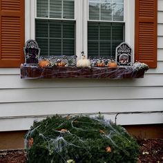 a window sill decorated for halloween with pumpkins and other decorations