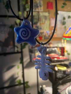 a blue and white snowflake hanging from a black cord with a star on it