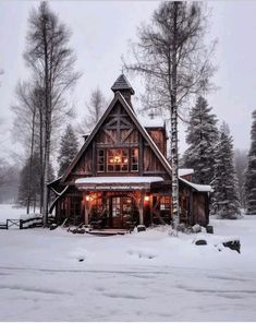 a cabin in the woods with snow on the ground