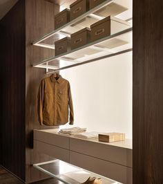 a jacket is hanging on a shelf in a room with shelves and drawers, along with other items