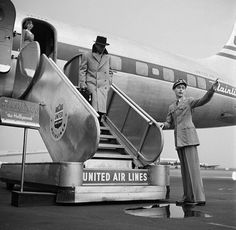 an old black and white photo of two people standing in front of a united air lines plane