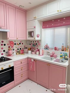 a pink kitchen with polka dots on the walls