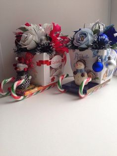 two vases filled with flowers sitting on top of a white counter next to each other