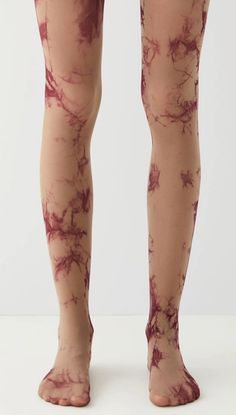 the legs and ankles of a woman with blood on her leg, wearing tight stockings