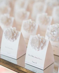 small white flowers are on display in a glass case at a wedding ceremony or reception