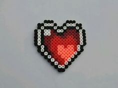 a red heart made out of black and white beads on a gray background with space for text