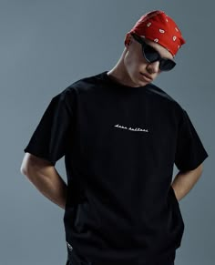 a young man wearing a red bandana and black t - shirt with white writing on it