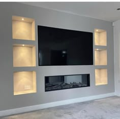 a living room with a flat screen tv mounted on the wall and built - in shelving