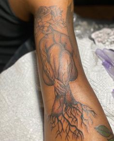 a man's arm with a tree tattoo on it