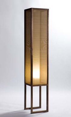 a tall wooden floor lamp with a white light on the top and bottom part of it