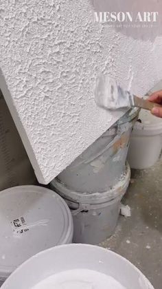 someone is painting the wall with white paint