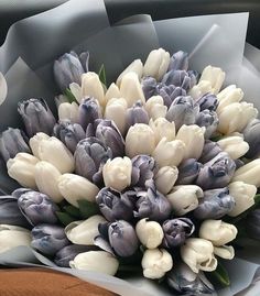 a bouquet of white and purple tulips