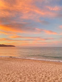 the sun is setting over the ocean and beach