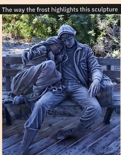 a statue of a man sitting on top of a wooden bench next to another person