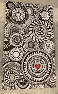 a black and white drawing with a red heart on the center, surrounded by circles