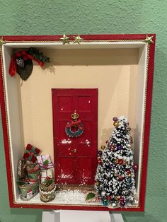 a christmas scene with a red door and small trees in front of it on a white pedestal