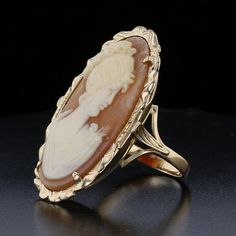 Description:This beautiful vintage Cameo Ring features a delicate hand-carved shell in an oval shape, set in 14K yellow gold. With a timeless design, this piece brings together the elegance of the past with a modern flair. A perfect addition for those who appreciate antique jewelry. Specifications: Metal: 14K Yellow Gold Weight: 5.9 grams Main Stone: Shell Main Stone Shape: Oval Main Stone Color: Orange Main Stone Size: 30x16 mm Vintage Style: Yes Item Code: 893511 Classic Oval Cameo Rings, Gold Oval Cameo Rings, Shell Carving, Classic Profile, Profile Portrait, Groom Accessories, Cameo Ring, Vintage Cameo, Carved Shell