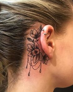 a woman's behind the ear tattoo is shown