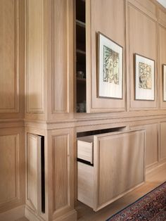 a room with wooden cabinets and pictures on the wall