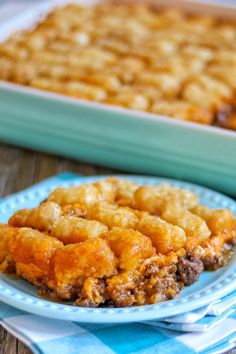 a blue plate topped with tater tots next to a casserole dish